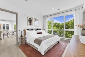 Englewood Cliffs apartment for rent - A bedroom with a large bed and a view of trees outside the window.