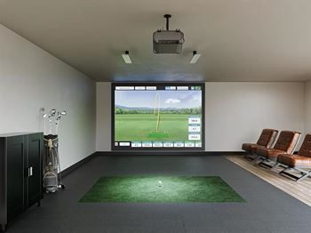 Indoor golf simulator room with putting green