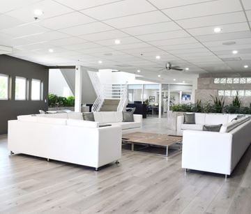 San Diego apartment for rent - A spacious living room with white furniture and wooden flooring.