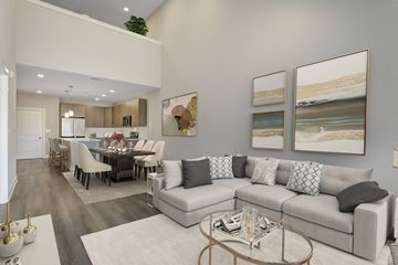Basking Ridge apartment for rent - A modern living room with a grey sofa, a glass coffee table, and a dining table set up.