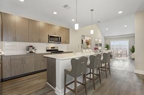 Basking Ridge apartment for rent - A kitchen with wooden cabinets and a white island with four chairs around it.
