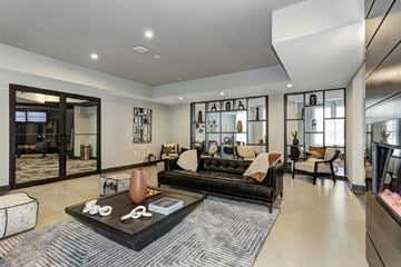 Hackensack apartment for rent - A modern living room with a black couch and a coffee table.