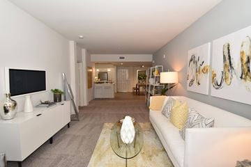 San Diego apartment for rent - A living room with a white couch and a glass coffee table.