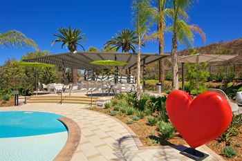 Pool area with heart sculpture and pergola