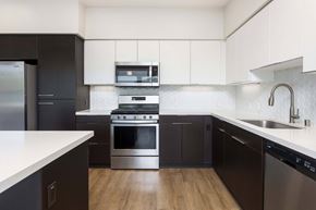 Irvine apartment for rent - Contemporary kitchen with two tone cabinets and hexagonal backsplash at Elements Apartments, Irvine, CA 92612