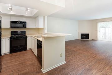 Sherman Oaks apartment for rent - A kitchen with black appliances and white cabinets.