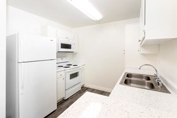 Toluca Lake apartment for rent - A white kitchen with a refrigerator, oven, and sink.