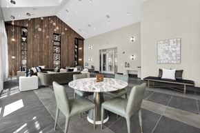 Roseland triplex for rent - A modern club room with a round table and grey chairs.