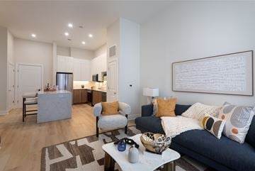 Newton apartment for rent - A modern living room with a grey couch and a large abstract painting on the wall.