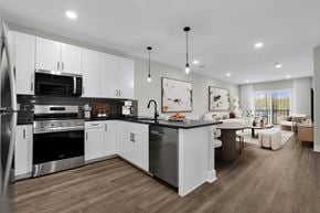 New Providence townhouse for rent - A modern kitchen with white cabinets and stainless steel appliances.