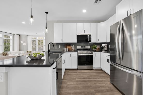 New Providence townhouse for rent - A modern kitchen with stainless steel appliances and white cabinets.