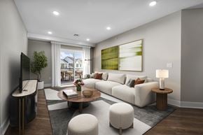 New Providence townhouse for rent - A modern living room with a large window, a white sofa, and a wooden coffee table.