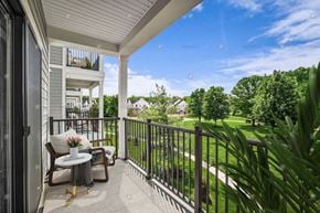 New Providence townhouse for rent - A balcony with a table and chairs overlooking a green lawn.