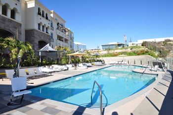 Resort style pool with lounge chairs and umbrellas