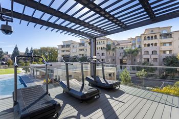 Rooftop fitness deck with curved treadmills and pergola