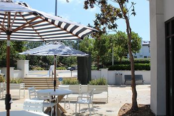 Outdoor patio dining with striped umbrellas and seating