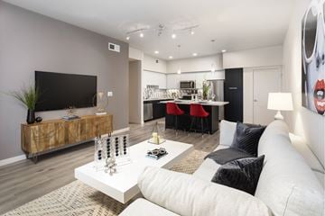 San Diego apartment for rent - A modern living room with a white sofa and a wooden sideboard.