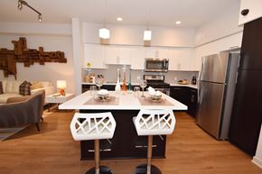 Irvine apartment for rent - A modern kitchen with a white table and chairs.at Metropolis Apartments, IRVINE, 92614