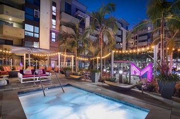 Twilight pool deck with palm trees and string lights