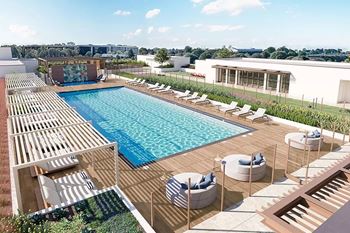 Rooftop pool area with wooden deck and shaded cabanas