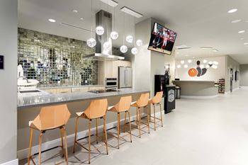 Modern clubhouse kitchen with bar seating and mirrored backsplash
