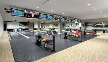 Private bowling lanes with colorful balls and overhead screens