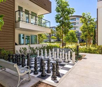 Outdoor chess board with oversized pieces and bench seating