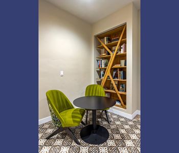 Cozy reading nook with bookshelf and velvet chairs