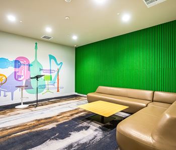 Music room with colorful wall mural and curved sofa