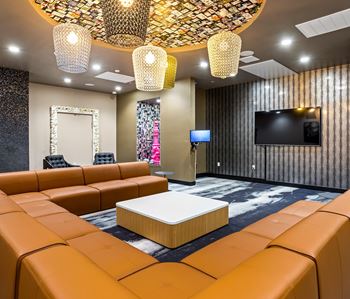 Resident lounge with pendant lights and sectional seating