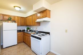 Elizabeth apartment for rent - A kitchen with white appliances and wooden cabinets.