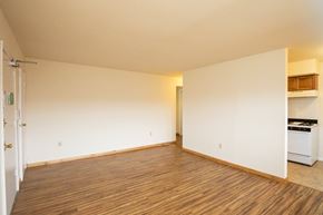 Elizabeth apartment for rent - A room with wooden flooring and a white wall with a door and a small cabinet.