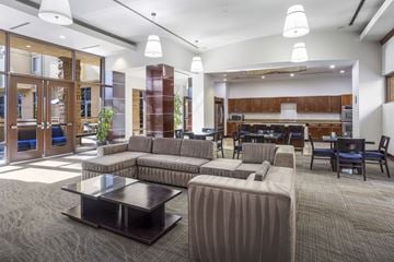 San Diego apartment for rent - A modern living room with a grey carpet and a coffee table in the center.