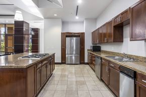 San Diego apartment for rent - A kitchen with brown cabinets and a stainless steel refrigerator.at Costa Verde Village Apartments, California