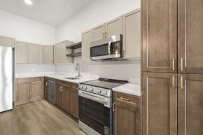 Idaho Falls apartment for rent - A kitchen with wooden cabinets and a stainless steel refrigerator.