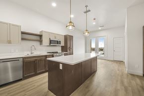 Idaho Falls apartment for rent - A modern kitchen with wooden cabinets and a central island.