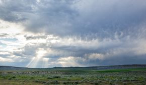 Casper apartment for rent - The sun is shining through the clouds over a green landscape.