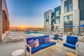 West Point apartment for rent - A sunset view of a pool area with a blue sofa and chairs.