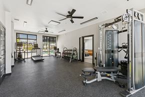Clearfield townhouse for rent - A spacious gym with a variety of equipment including a squat rack, bench, and weights.