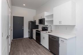 Provo apartment for rent - a kitchen with white cabinets and a black refrigerator