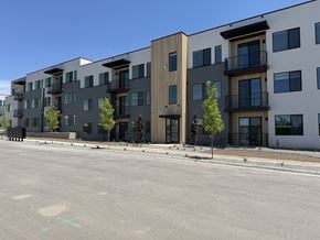 Layton apartment for rent - A row of modern apartment buildings with balconies and trees in front.