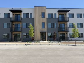 Layton apartment for rent - A modern apartment building with balconies and trees in front.