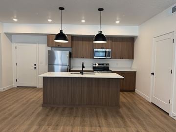 Layton apartment for rent - A modern kitchen with wooden cabinets and a center island.