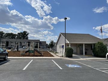Laramie apartment for rent - A parking lot with a playground and a building in the background.