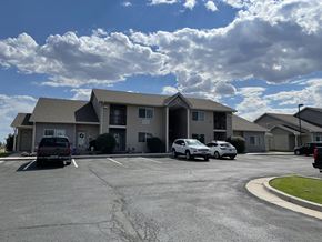 Laramie apartment for rent - A parking lot in front of a building with cars parked.