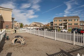 Rexburg apartment for rent - a fenced in dog park in front of a building