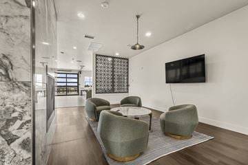 Idaho Falls apartment for rent - A modern living room with a grey sofa and a TV on the wall.