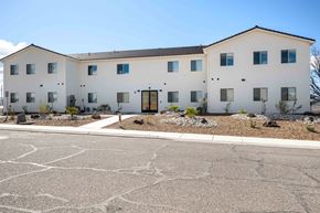Hurricane apartment for rent - a large white building with a street in front of it