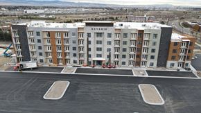 Idaho Falls apartment for rent - A large multi-story apartment building named Reverie sits in a parking lot.