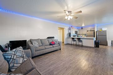 Saint George apartment for rent - A living room with a grey couch and a ceiling fan.